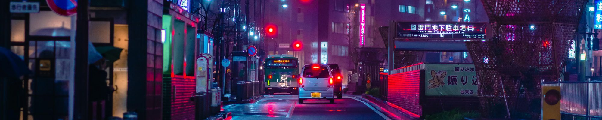 Nasse Nachtstrasse mit leuchtenden Neonreklamen